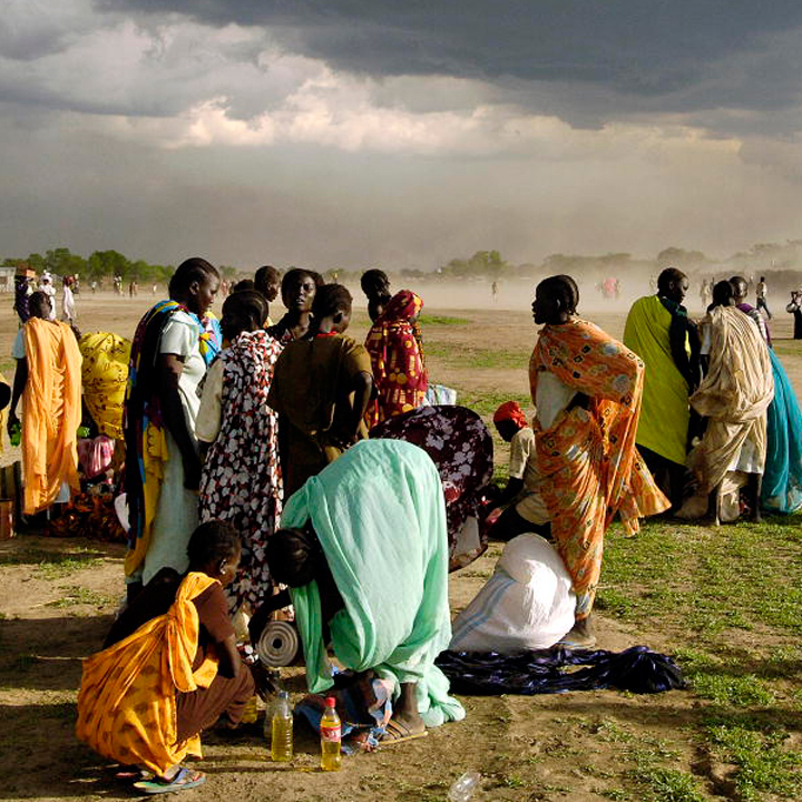 Women speaking in groups on a dusty plain