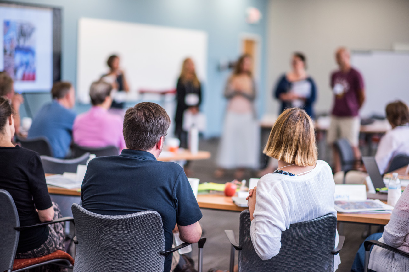 People sitting at tables watching a presentation