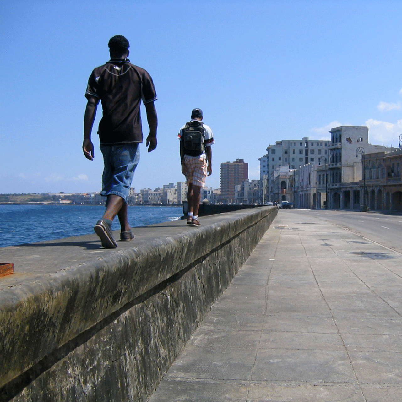 Two men walk along an embankment