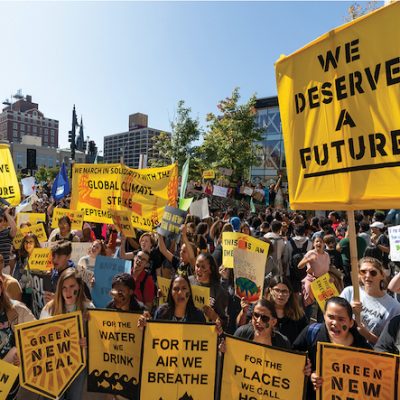Climate change protestors holding yellow signs
