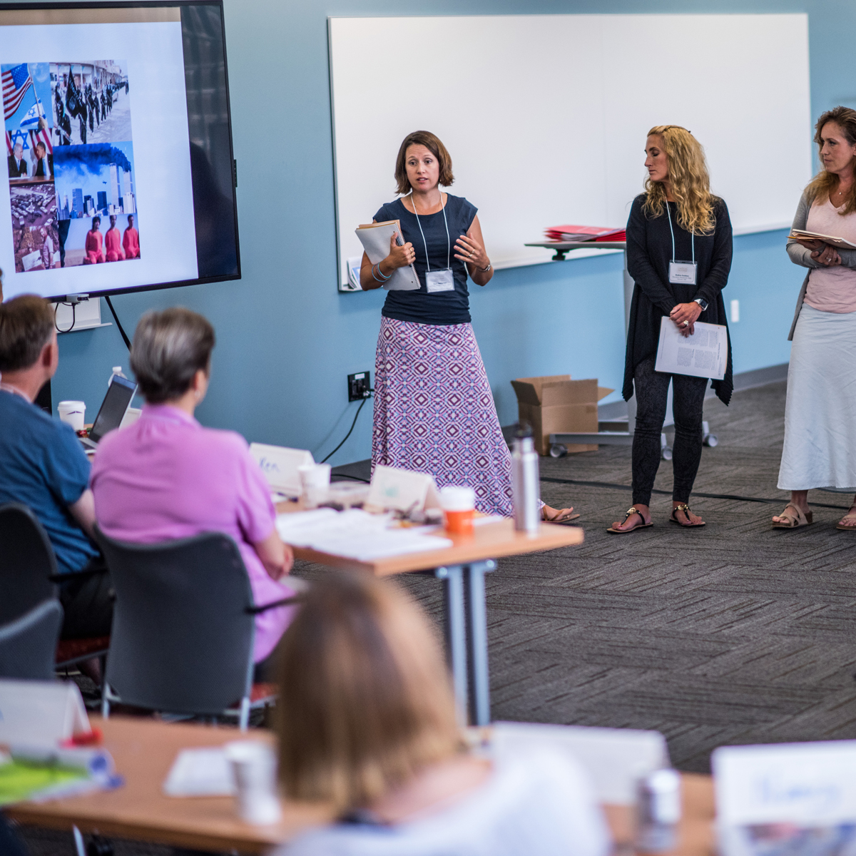 Woman giving presentation to room of adults