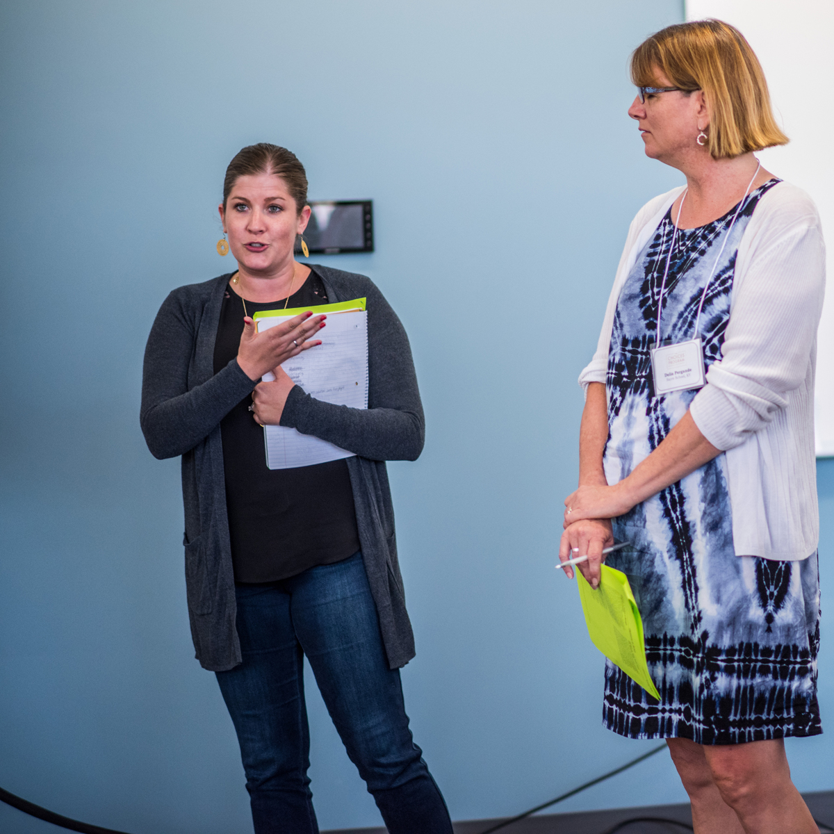 A women holding a notepad speaks