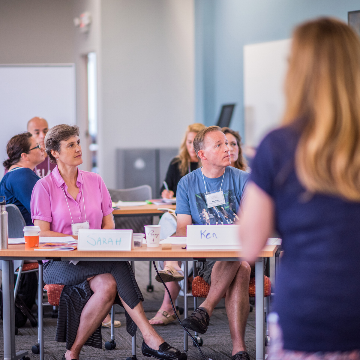 People sitting at desks watching a presentation