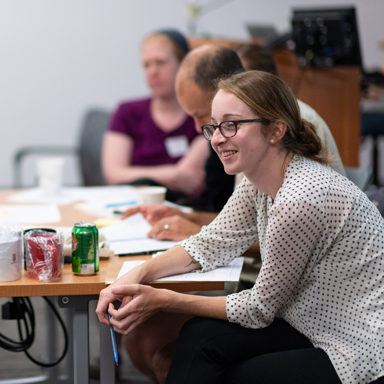 People sitting at a desk and watching a presentation