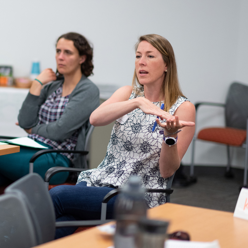 Woman sitting at a desk explaining something