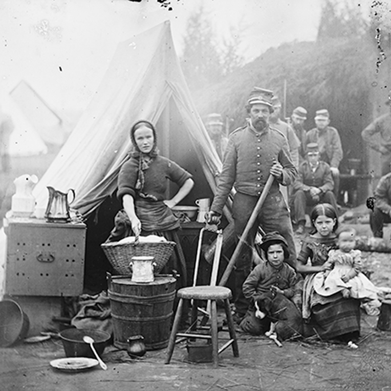 Black and white photo of a family and soldiers in a civil war camp