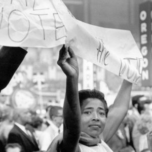 Black and white photo of a civil rights protestor holding up a banner