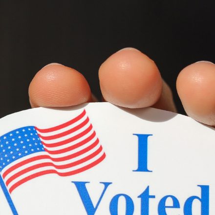 Close-up of someone holding up an I voted sticker