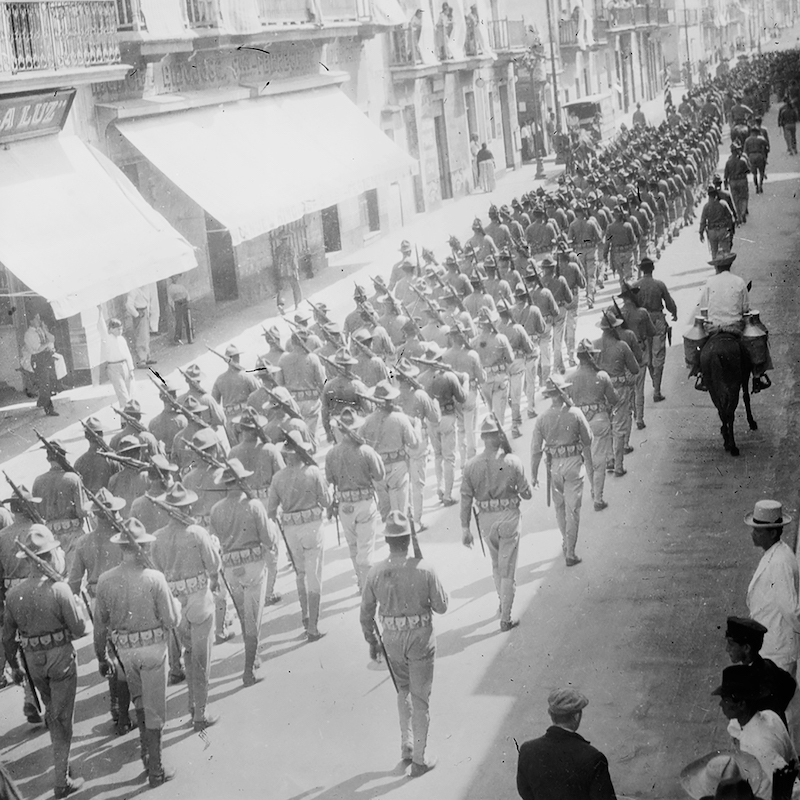 Black and white photo of lines of troops marching down a street in Veracruz, Mexico