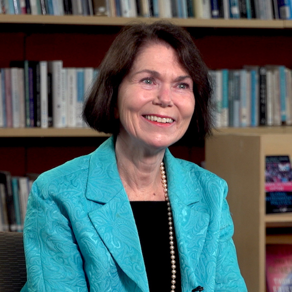 Deborah Hurley seated in front of book shelves.