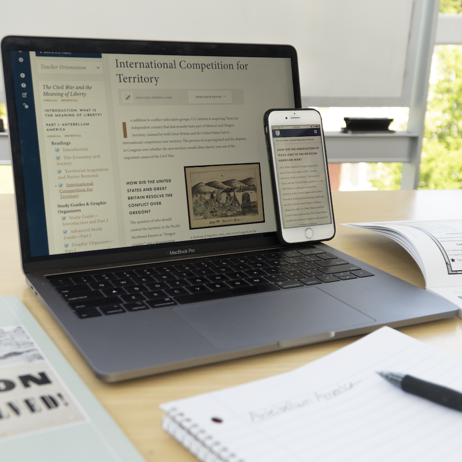 A laptop and cell phone on a desk with Choices Program's Digital Editions Civl War curriculum on the screens. A notebook and print copies of the curriculum unit are also on the table.