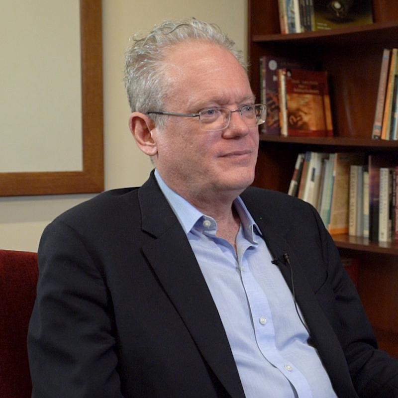 Image of Seth Jacobs as he appears in the Choices videos series, seated in front of a bookshelf.